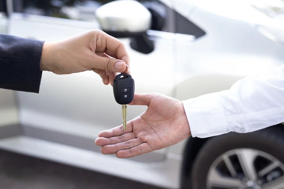 Remise de clés de véhicule entre deux personnes dans un environnement automobile professionnel