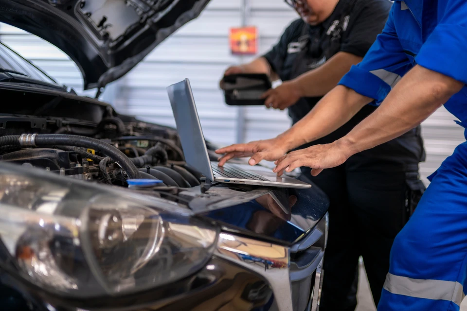 Remise de cl&eacute;s de v&eacute;hicule entre deux personnes dans un environnement automobile professionnel